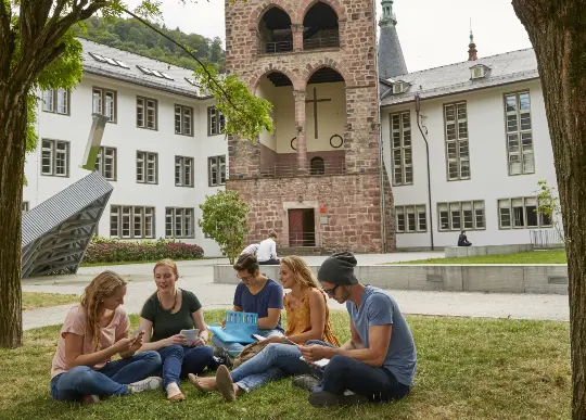 Studenten vor der Universität in Heidelberg Auf Klassenfahrt mit HEROLÉ: Die Universität in Heidelberg ist auch für Schüler einen Besuch wert.