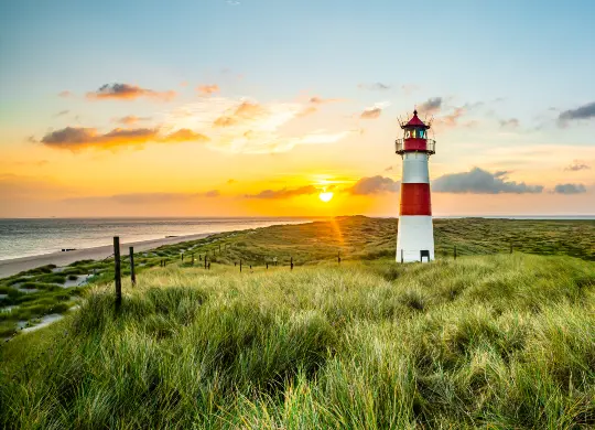 Auf Klassenfahrt mit HEROLÉ: Leuchturm bei Sonnenuntergang an der Nordseeküste
