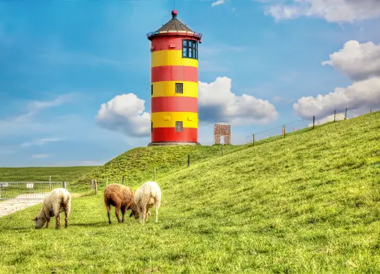 Leuchturm Nordsee Auf Klassenfahrt mit HEROLÉ: Ein rot-gelber Leuchtturm an der Nordseeküste.