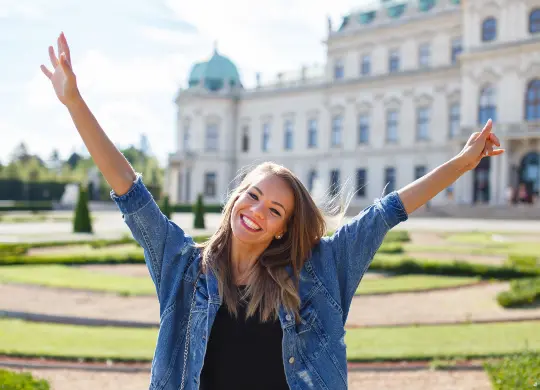 Auf Klassenfahrt mit HEROLÉ: Junge frau freut sich im Garten von Belvedere in Wien