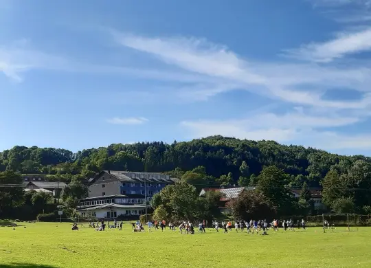 Auf Klassenfahrt mit HEROLÉ: Außenansicht mit Spielwiese der Jugendherberge Oberbernhards in der Rhön
