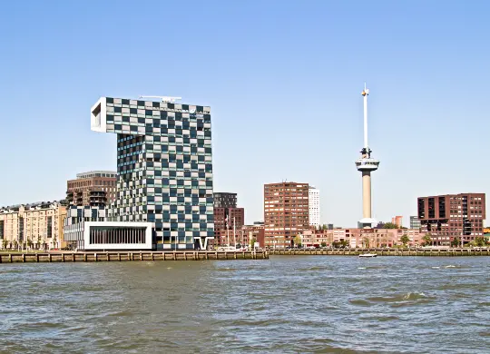 Auf Klassenfahrt mit HEROL&Eacute;: Hohes Geb&auml;ude am Fluss in Rotterdam