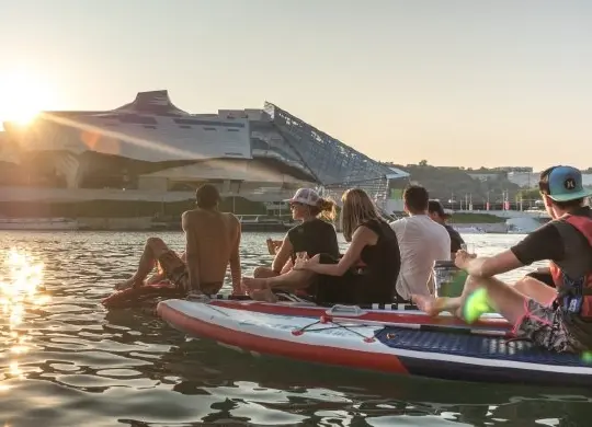 Auf Klassenfahrt mit HEROL&Eacute;: Abendstimmung auf dem SUP und Sonnenuntergang hinter dem Confluence Museum in Lyon