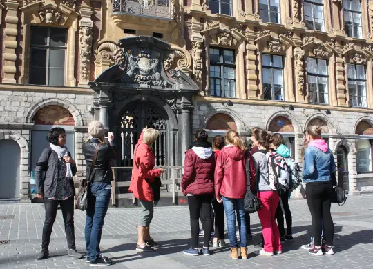 Reisegruppe auf Stadtführung in Lille Auf Klassenfahrt mit HEROLÉ: Reisegruppe auf Stadtführung in Lille vor der Alten Börse