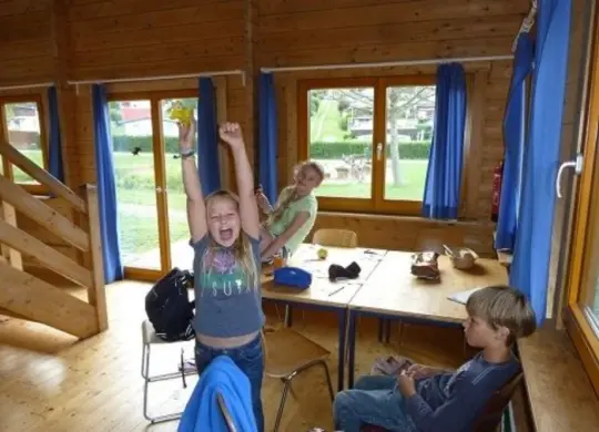 Auf Klassenfahrt mit HEROLÉ: Aufenthaltsbereich in einem Blockhaus im NabeDi Camp in der Eifel