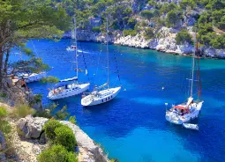 Auf Klassenfahrt mit HEROLÉ: Boote ankern in glasklarem Wasser an der Côte d'Azur.