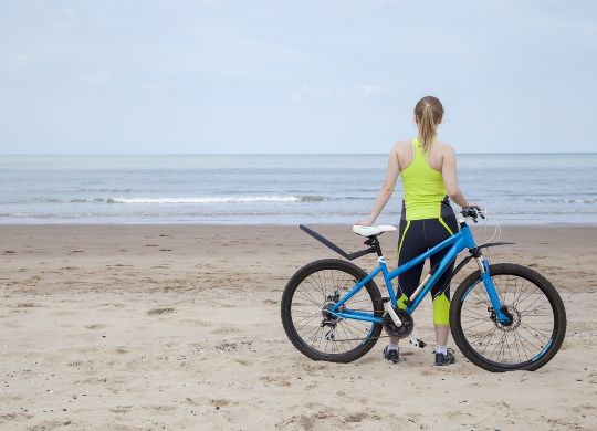 Klassenfahrten Flämische Nordsee - Mädchen mit Fahrrad am Strand Klassenfahrten Flämische Nordsee - Mädchen mit Fahrrad am Strand