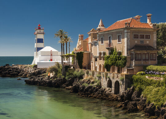Auf Klassenfahrt mit HEROLÉ: Küste mit kleinen Häusern und einem Leuchtturm in Lissabon