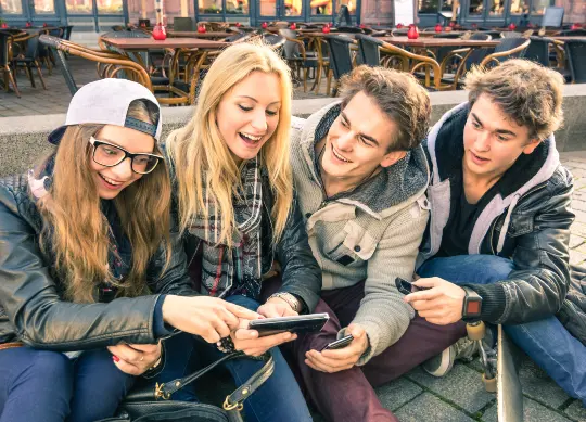 Jugendgruppe sitzt auf dem Bordstein in Berlin  Auf Klassenfahrt mit HEROLÉ: Jugendgruppe sitzt auf dem Bordstein in Berlin.