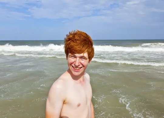 Auf Klassenfahrt mit HEROLÉ: Junge am Strand vor den Wellen der an der Nordsee