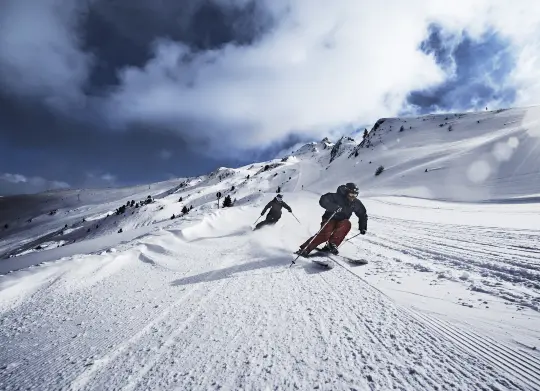 Skifahrer auf Abfahrt in Tirol  Auf Klassenfahrt mit HEROLÉ: Skifahrer auf Abfahrt in Tirol.
