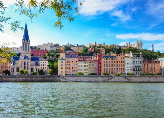 Auf Klassenfahrt mit HEROL&Eacute;: Blick &uuml;ber die Sa&ocirc;ne auf die farbenfrohe H&auml;userfront in Lyon.