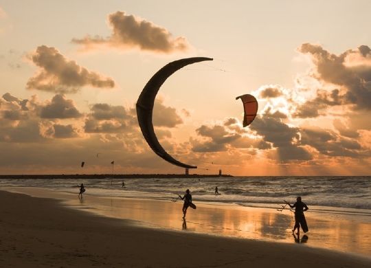 Klassenfahrten Niederländische Nordseeküste - Strandaktivität Paragliding Klassenfahrten Niederländische Nordseeküste - Mehrere Paraglider am Strand beim Sonnenuntergang