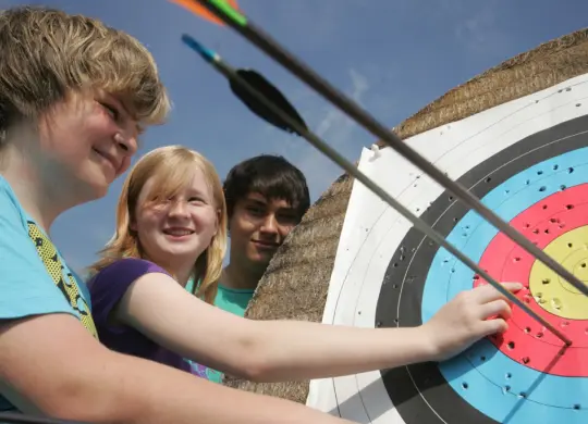 Auf Klassenfahrt mit HEROLÉ: Gruppe beim Bogenschießen üben an der Nordsee