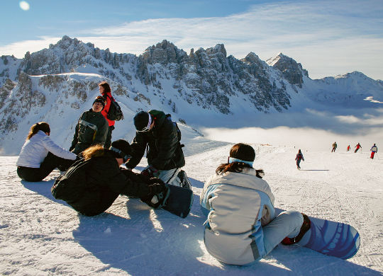 Pause im Stubaital Auf Klassenfahrt mit HEROLÉ: Schüler pausieren mit ihren Snowboards auf der Piste im Stubaital