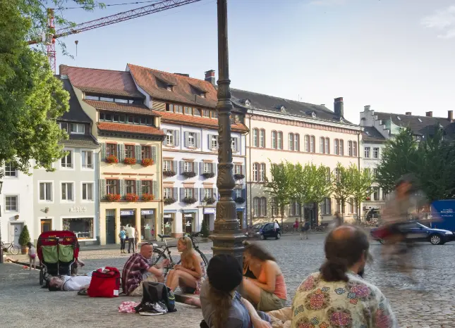 Ein Platz mit Menschen in Freiburg Auf Klassenfahrt mit HEROLÉ: Entdecken Sie die Universitätsstadt Freiburg mit mildem Klima