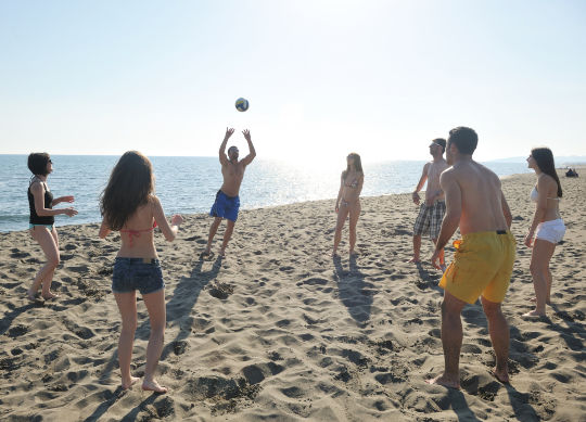 Schülergruppe beim Volleyball spielen am Strand in der Provence Auf Klassenfahrt mit HEROLÉ: Nutzen Sie die Sonnenstunden für eine runde Volleyball am Strand in der Provence