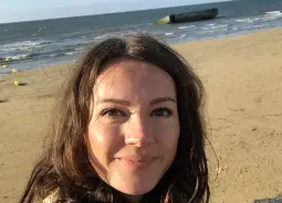 Auf Klassenfahrt mit HEROLÉ: Kundenberaterin Monique am Strand von Arromanches in der Normandie