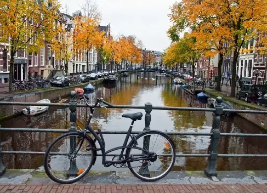 Gracht in Amsterdam Auf Klassenfahrt mit HEROLÉ: Fahrrad an einer Brücke in Amsterdam