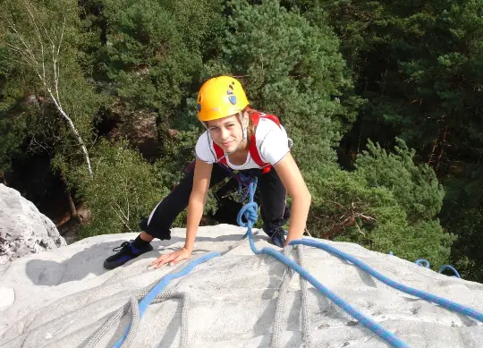 Ein Mädchen klettert einen Felsen hinauf in der Sächsischen Schweiz Auf Klassenfahrt mit HEROLÉ: Klettern Sie auch die Felsen in der Sächsischen Schweiz hinauf