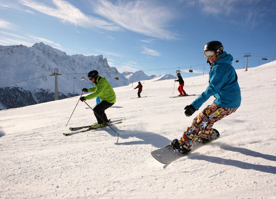 Jugendliche bei der Skiabfahrt im Skigebiet in Savognin Auf Klassenfahrt mit HEROLÉ: Fahren Sie bei schönen Wetter auch auf den Pisten in Savognin