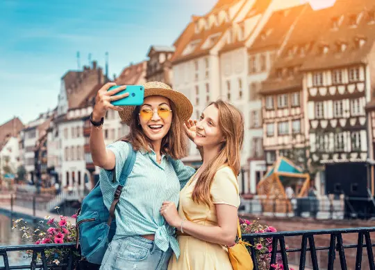 Auf Klassenfahrt mit HEROLÉ: Schülerinnen machen ein Selfie vor Fachwerkhäusern in Straßburg