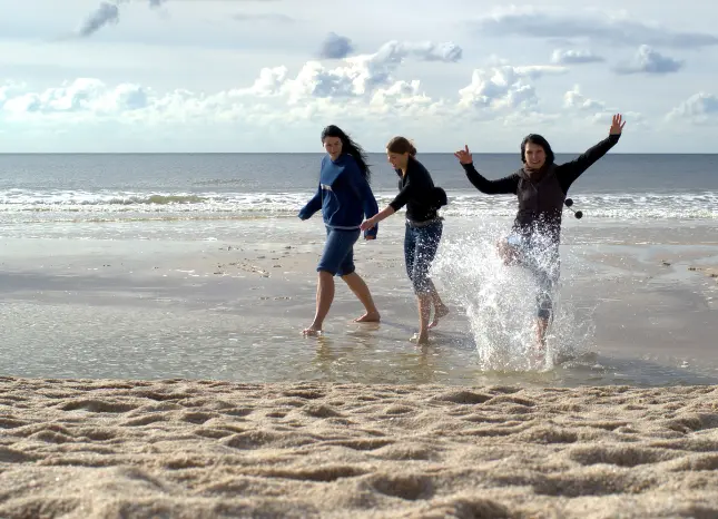 Auf Klassenfahrt mit HEROLÉ: Jugendliche beim Strandspaziergang an der Nordseeküste