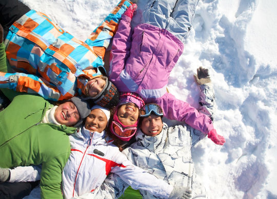 Ski-Klassenfahrten Zillertal - Jugendliche im Schnee Ski-Klassenfahrten Zillertal - 5 Jugendliche liegen freudig im Schnee