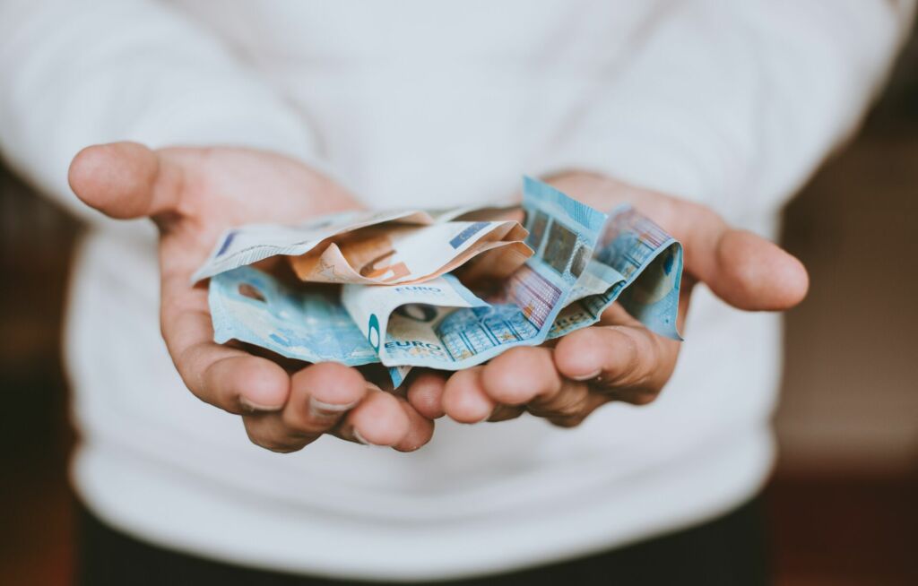 Hände mit Euro-Banknoten.