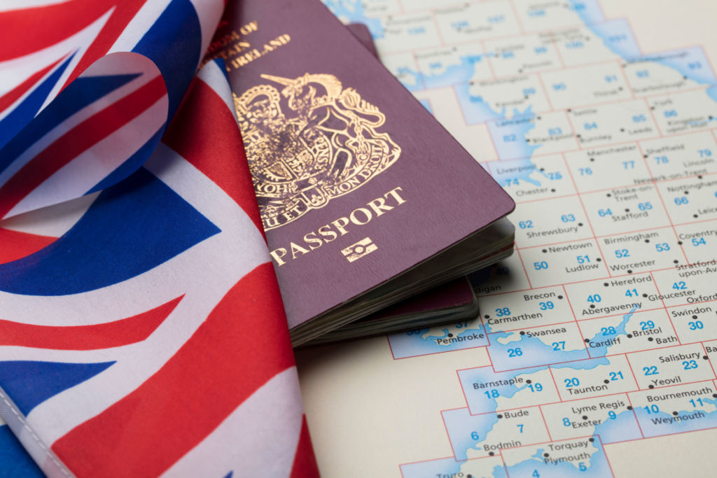 Ein britischer Reisepass, eine Union Jack-Flagge und eine Landkarte von Großbritannien