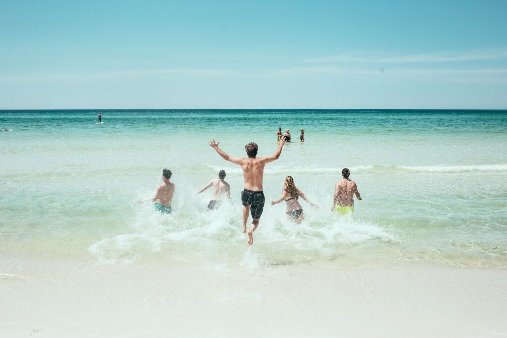 Schüler springen am Strand ins Wasser
