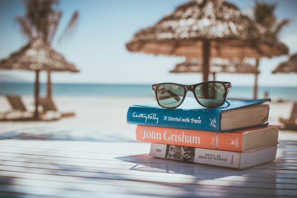 Blick auf einen STabel Bücher am Strand