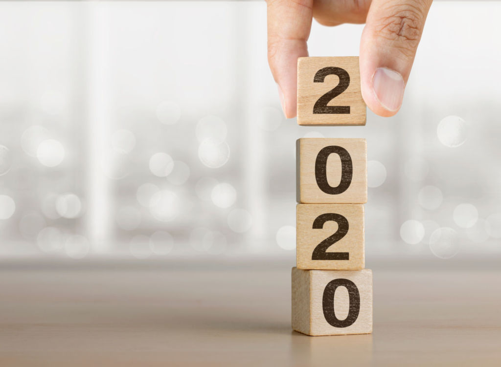 Holzwürfel mit den Jahreszahlen 2020 werden aufeinandergestapelt.
