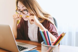 Junge Frau sitzt verzweifelt vor ihrem Laptop