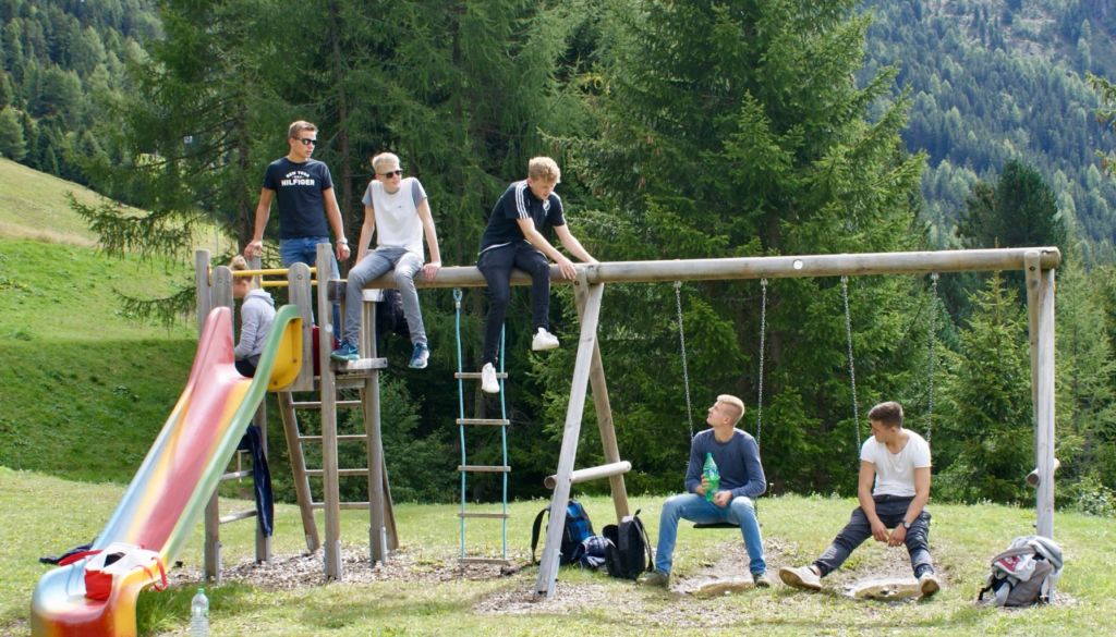 Blick auf Schüler, die in Tirol auf einem Klettergerüst sitzen