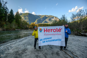 Geschäftsführer Carsten Herold von HEROLÉ Reisen und Kai Andersch von Wilderness International halten ein HEROLÉ-Plakat in den Händen.