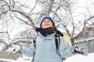 Junge Schülerin freut sich über den Schnee.