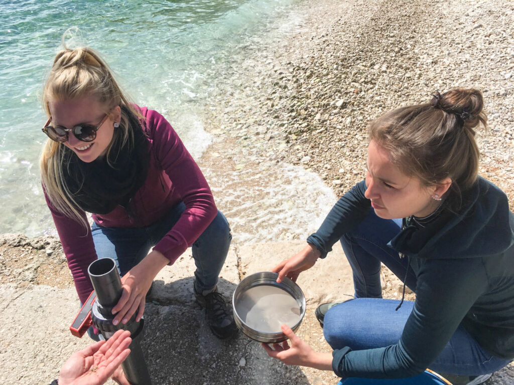 Zwei Schülerinnen entnehmen im Rahmen unseres Mittelmeer Mikroplastik Projekts Sedimentproben, um diese auf ihren Plastikgehalt zu untersuchen.