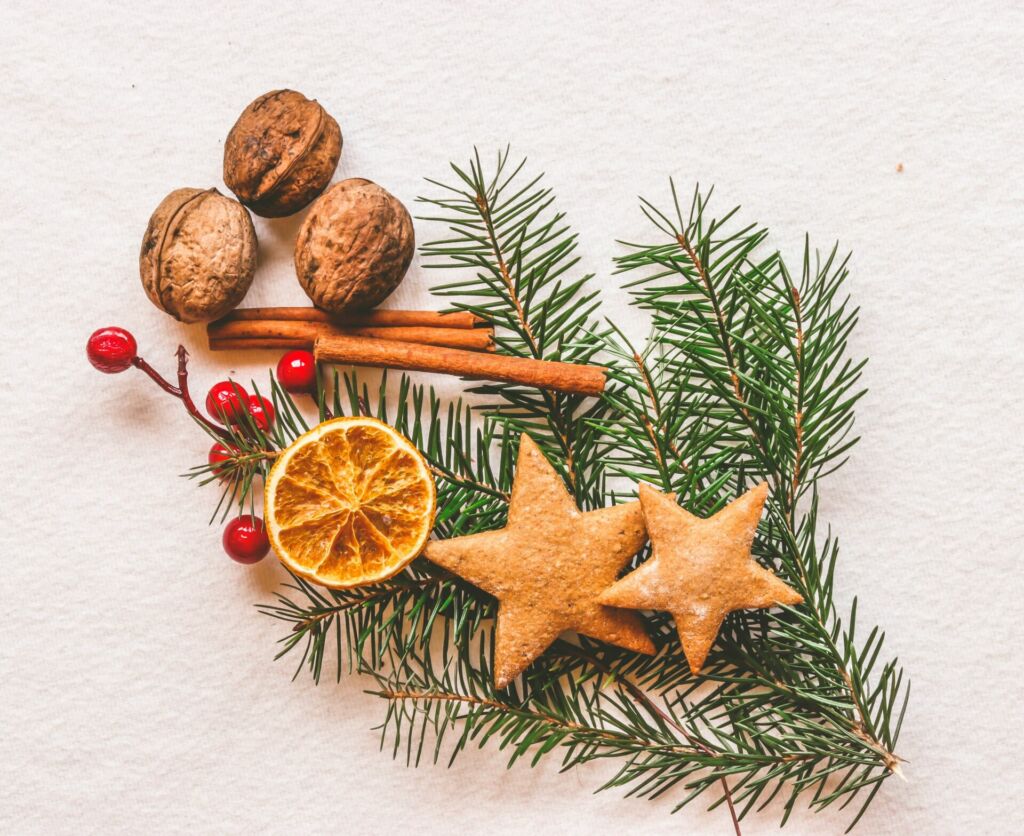 Plätzchen und weihnachtliche Dekoration liegen auf einem Tisch.