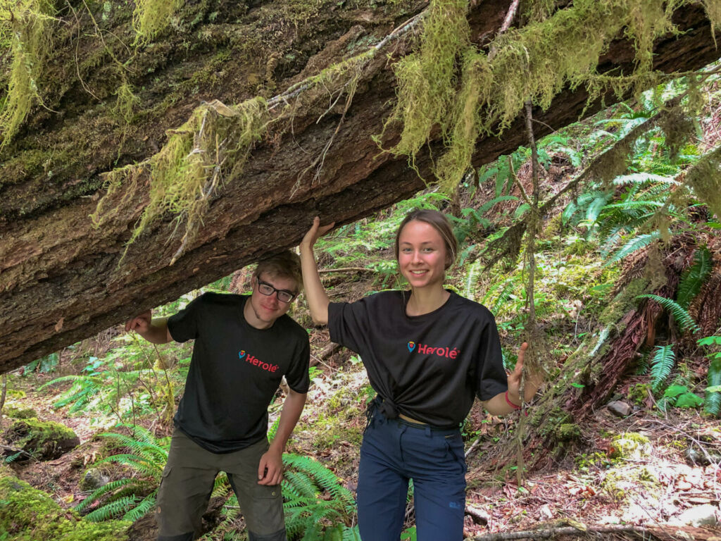 Zwei Schüler stehen mitten im kanadischen Regenwald.