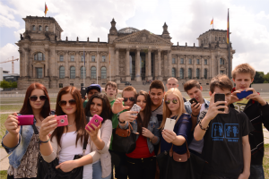 Eine Schülergruppe auf Klassenfahrt vor dem Bundestag in Berlin ein Selfie.