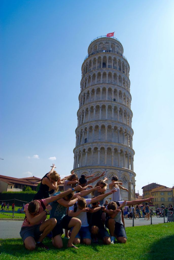 Schüler machen ein Selfie vor dem schiefen Turm von Pisa.