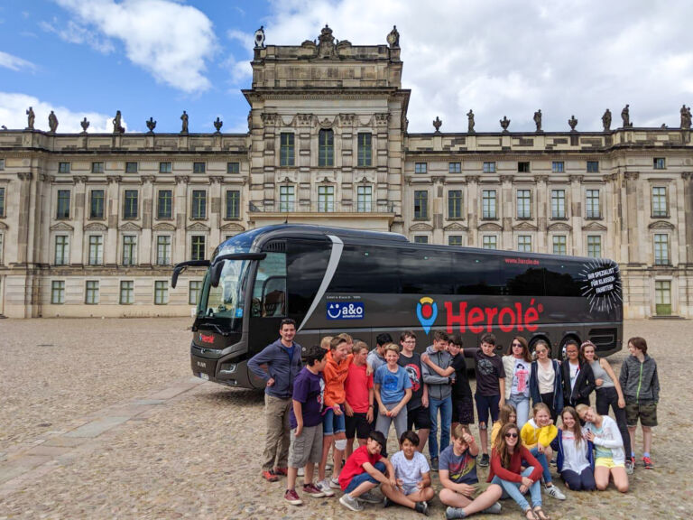 Portrait einer Schülergruppe auf Klassenfahrt vor einem Reisebus von HEROLÉ