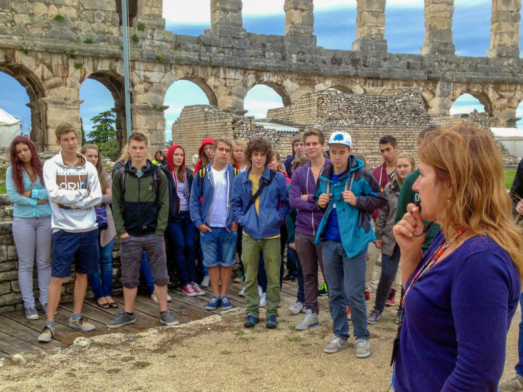 Die istrische Reiseleiterin Marina mit einer Klasse Amphitheater Pula.